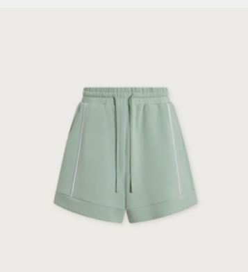 A pair of sage green athletic shorts with a drawstring waist and white piping details, shown against a light gray background.