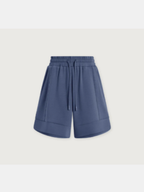 A pair of slate blue athletic shorts with an elastic waistband and drawstring, shown against a light gray background.