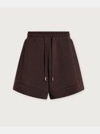 Dark brown high-waisted shorts with a drawstring waist, displayed on a light beige background.